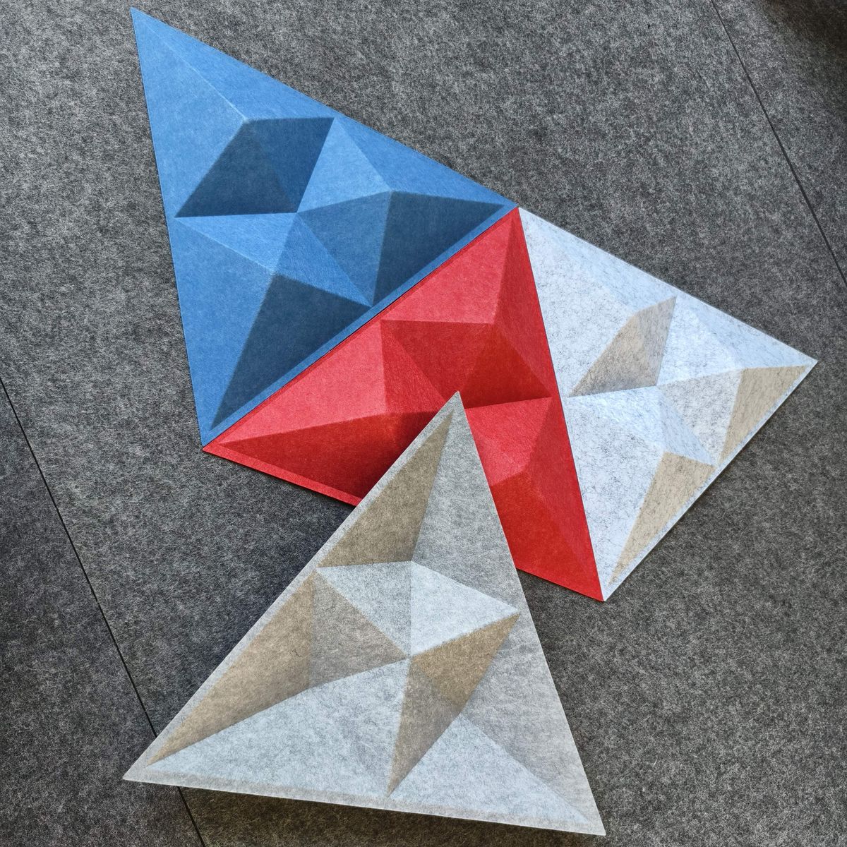 Tri&aacute;ngulos facetados de PET en azul, rojo y gris
